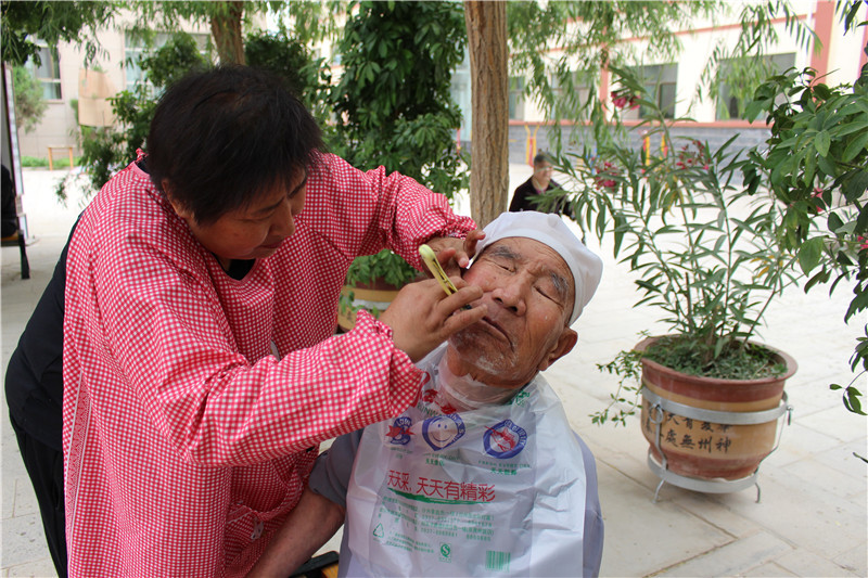 理发师带来专业美发工具,为老人们现场理发,刮脸,洗头,娴熟的技艺得到